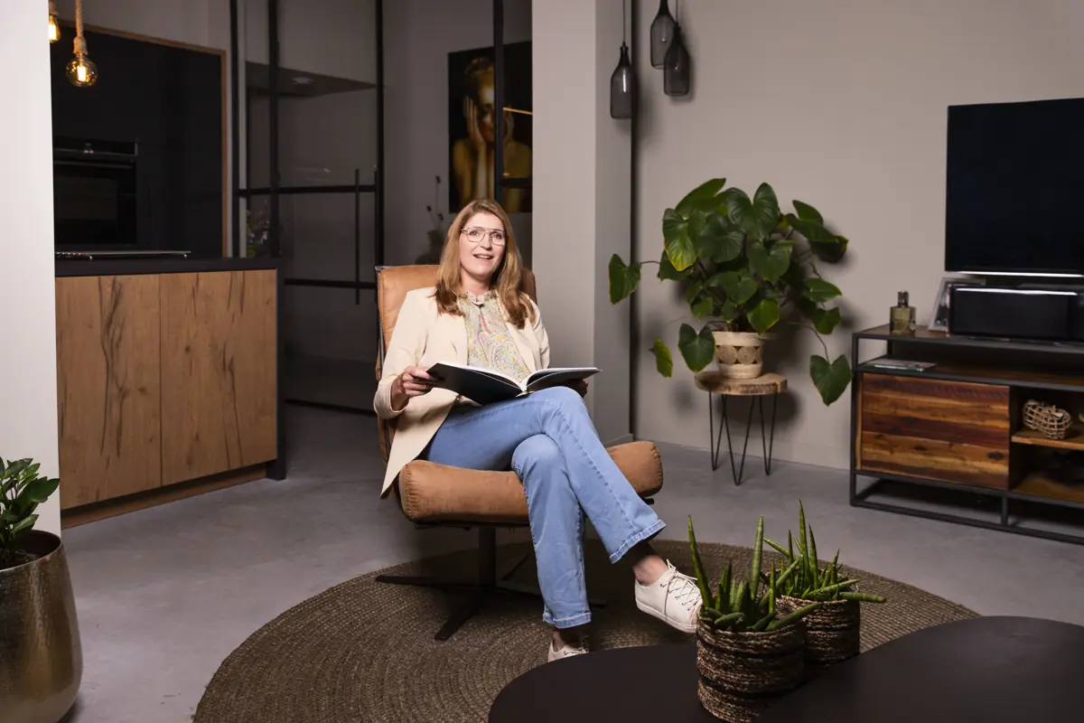 Vrouw leest boek in woonkamer