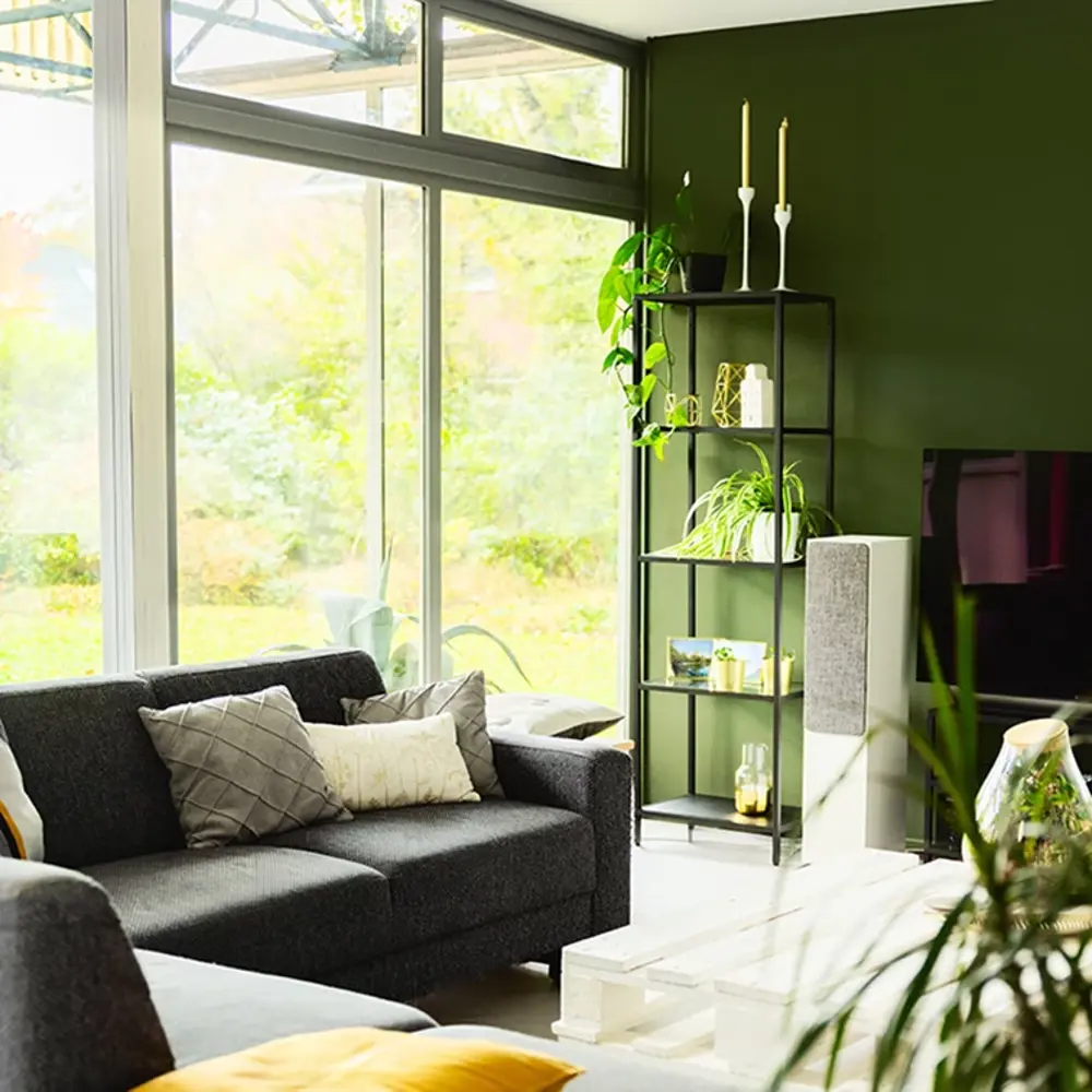 Het interieur vam het huis van Coralien, er is een bank voor een raam te zien en een open kast.