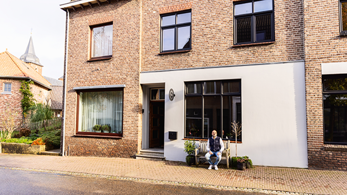 Man op bankje  voor eigen woning