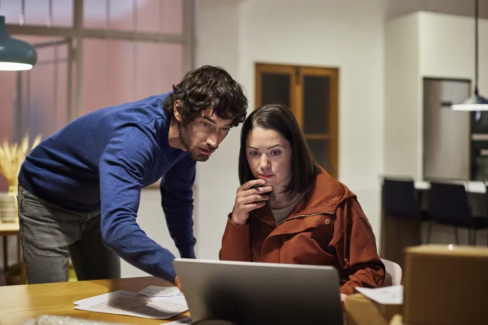 Man en vrouw bekijken samen iets op een laptop.
