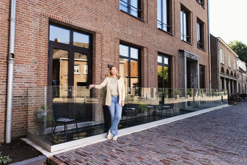 Vrouw poseert bij nieuwbouwwoning