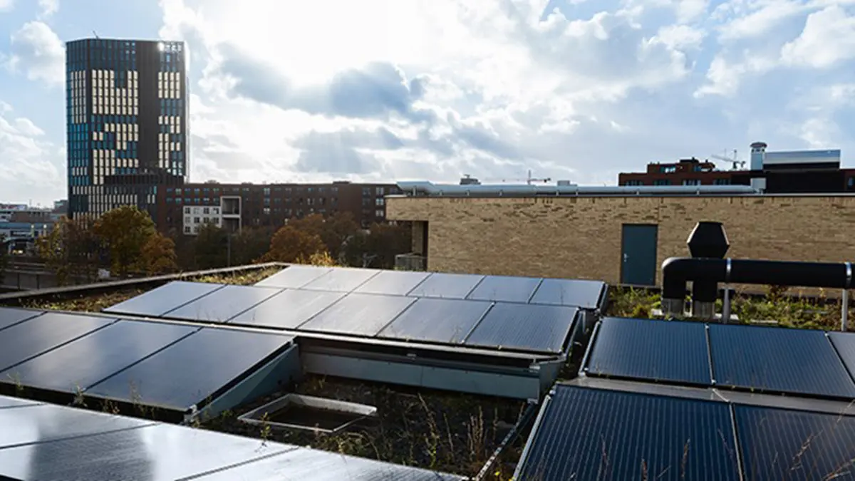 Zonnepanelen bovenop een dak van een appartementengebouw in Amsterdam.