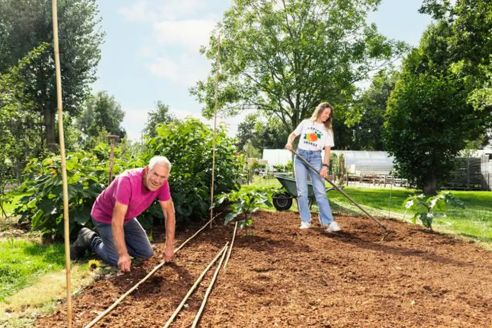 Vader en dochter aan het werk in de moestuin