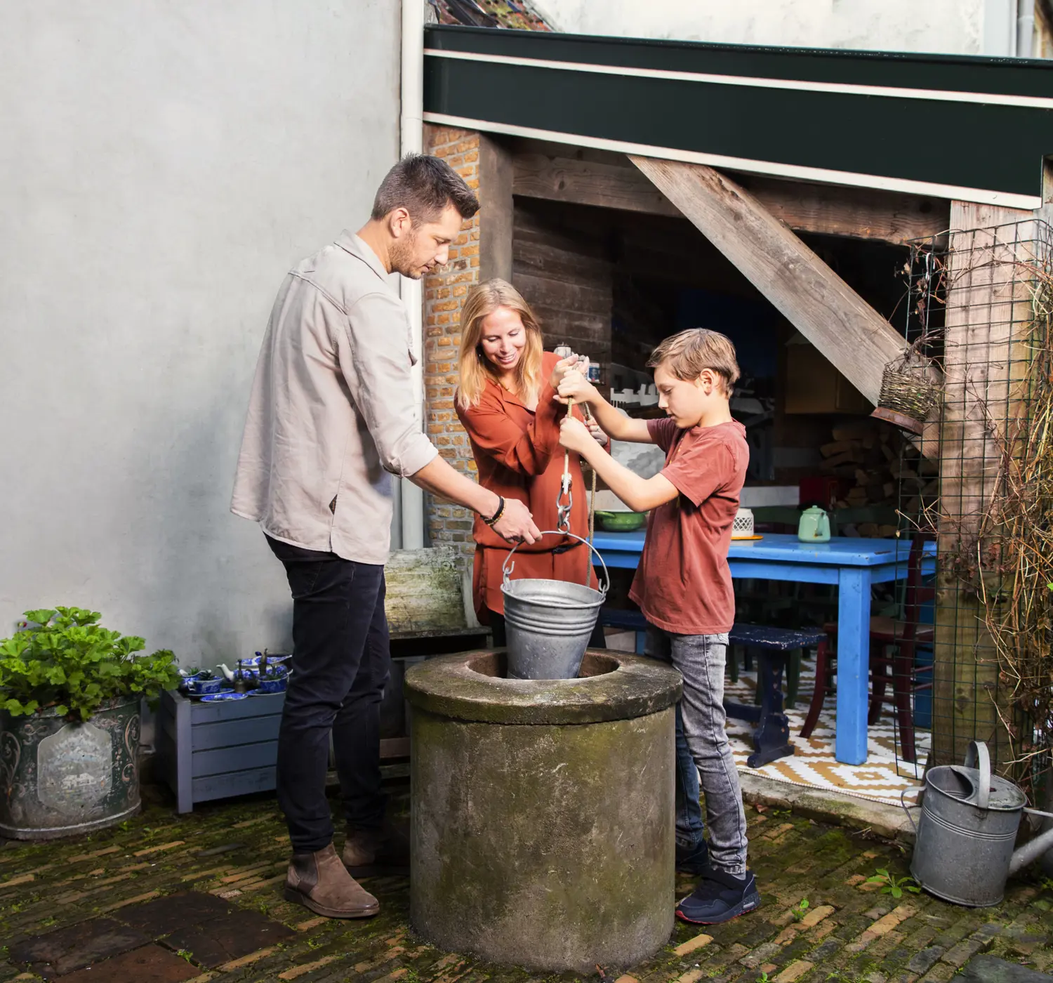 Gezin staat bij waterpomp