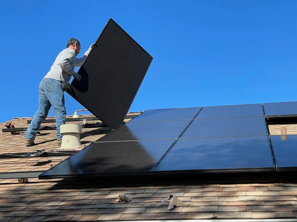 Installateur legt zonnepanelen op een dak