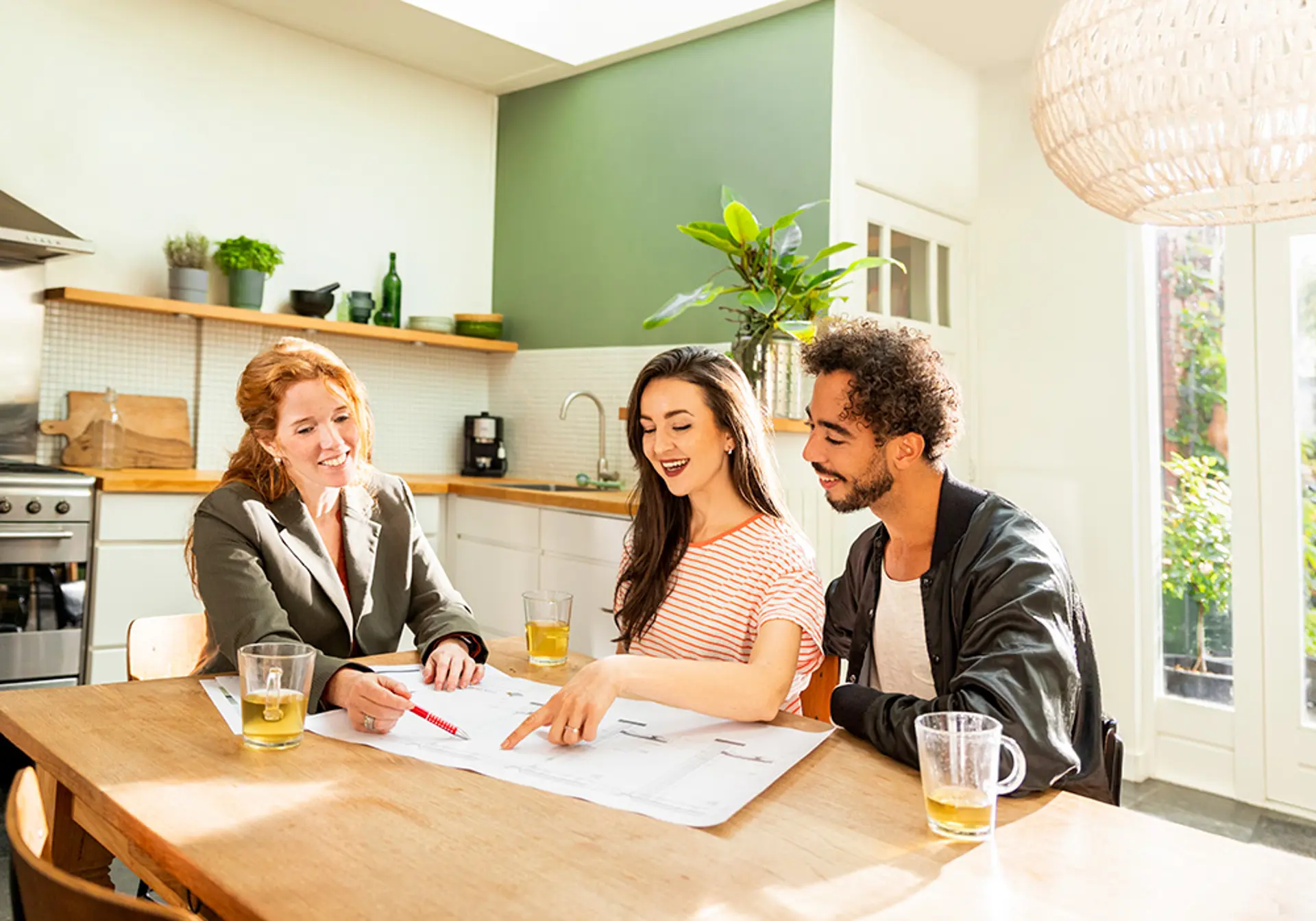 Adviseur zit met klanten aan keukentafel