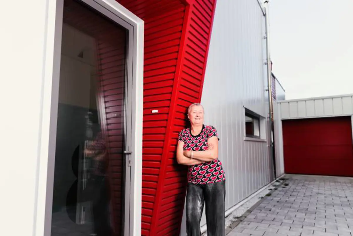 Vrouw bij eigen gebouwde huis van zeecontainers